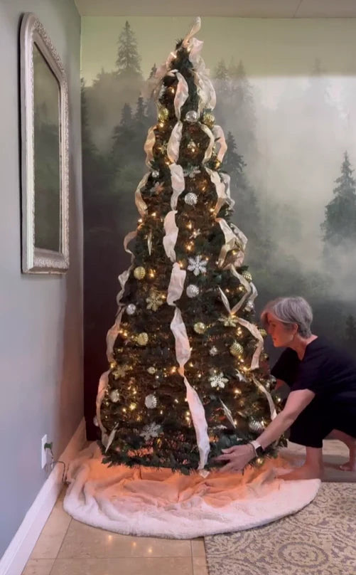 Sapin de Noël décoré avec rubans blancs dans un coin du salon
